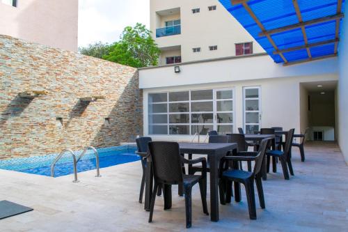 a patio with a table and chairs next to a pool at Hotel Continental Plaza in Barranquilla