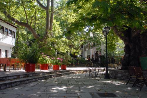 a park with benches and trees and a street light at Hotel Filoxenia in Portariá