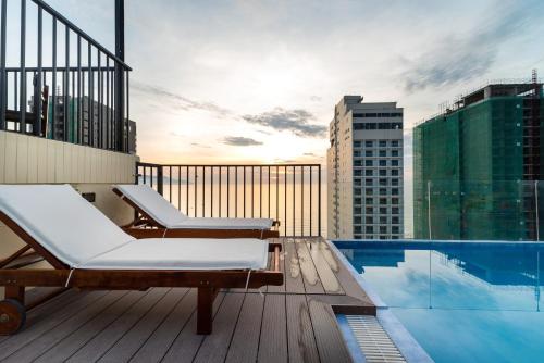a balcony with a pool and chairs on a building at Nhat Minh Hotel and Apartment in Da Nang