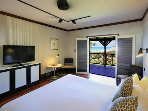 a hotel room with two beds and a television at Cable Beach Club Resort & Spa in Broome