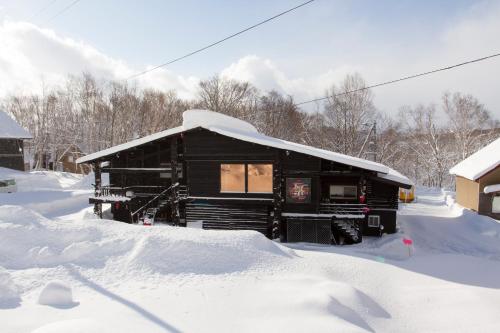 a house covered in snow with snow on top of it at Niseko Backcountry Lodge in Niseko