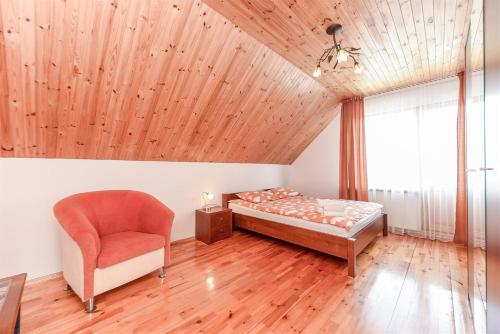 ein Schlafzimmer mit einem Bett und einem Stuhl in der Unterkunft Birutes Houses in Druskininkai