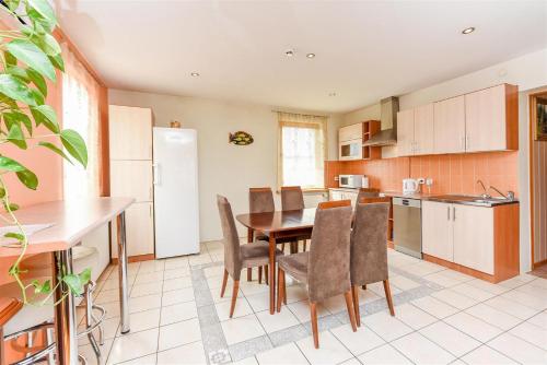 a kitchen with a table and chairs and a refrigerator at Birutes Houses in Druskininkai