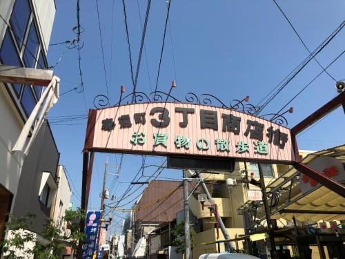 a sign for a restaurant on a city street at Yadokari House in Okayama