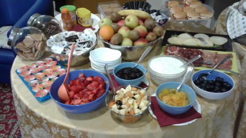 a table with bowls of fruit and bowls of food at Residence Delta in Rovigo