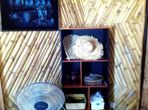 a shelf with a fan and pictures on a wall at Scoop Cabana Kitesurfing in Kalpitiya