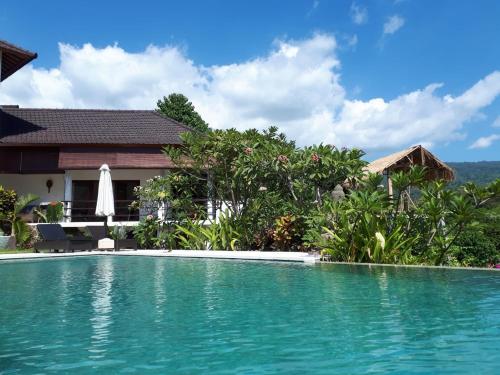a swimming pool in front of a villa at Lovina Paradise in Lovina