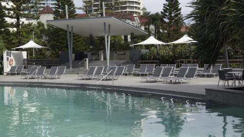 a pool with chairs and a group of tables and umbrellas at Private Apartment with Ocean Views at Q1 Resort in Gold Coast