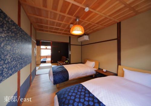 a hotel room with two beds and a lamp at Houka in Kyoto