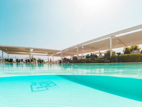 a large swimming pool with blue water in a building at Kora Park Resort in Formia