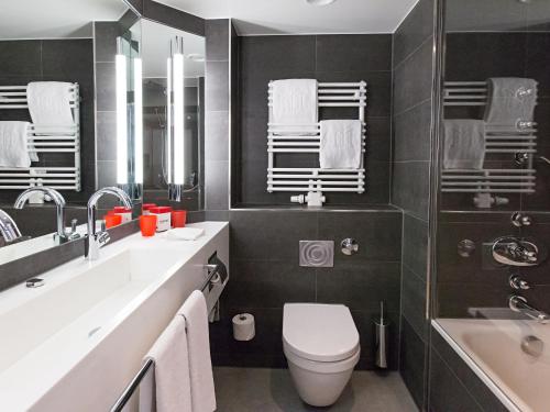 uma casa de banho com um WC, um lavatório e uma banheira em DORMERO Hotel Stuttgart em Estugarda