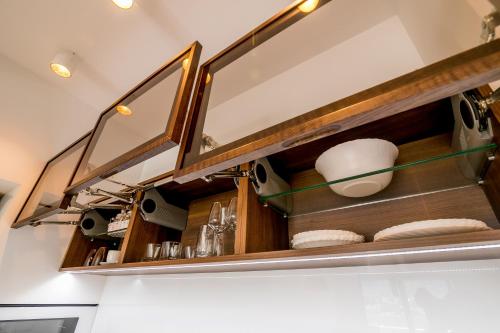 a kitchen with a shelf with dishes on it at Apartments Magic Sea View in Kotor