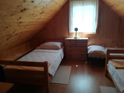 a attic bedroom with two beds and a window at Kuća Za Odmor Barbara in Donja Stubica