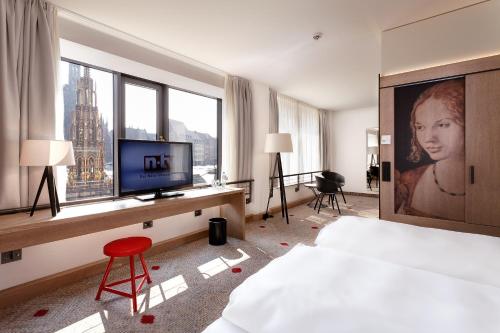 a hotel room with a bed and a television in it at Sorat Hotel Saxx Nürnberg in Nuremberg