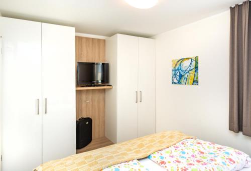 a bedroom with white cabinets and a bed at Ferienresidenz "Seelust" Whg 5 in Waren