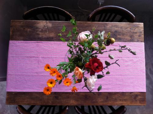 a table with a vase of flowers on it at La Vieille Auberge in Vesc