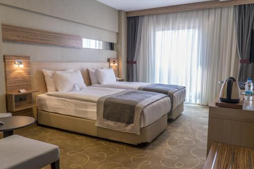 um quarto com uma cama grande num quarto de hotel em Greymark Hotel em Esmirna