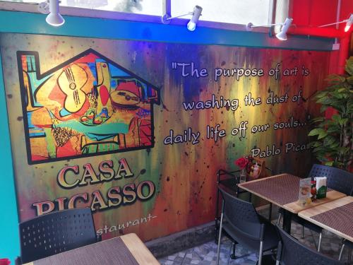 a wall in a restaurant with a sign on it at Casa Picasso Near Chabad House in Bangkok