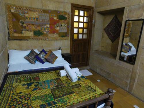 a bedroom with a bed and a mirror at Shahi Palace Hotel Jaisalmer in Jaisalmer