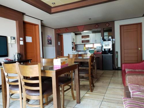 uma cozinha e sala de jantar com mesa e cadeiras em Plus Motel em Busan