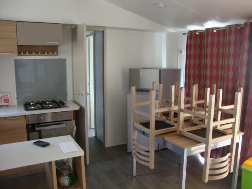 une cuisine avec une table et des chaises dans une cuisine dans l'établissement les sables du midi, à Valras-Plage