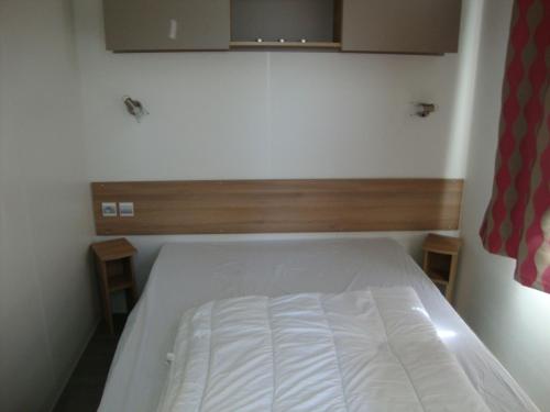 - une petite chambre avec un lit blanc dans l'établissement les sables du midi, à Valras-Plage