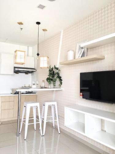 a kitchen with white stools and a flat screen tv at Pinnacle PJ @ Penguin Homes in Petaling Jaya
