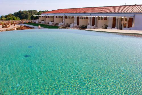 a large swimming pool in front of a house at Hotel Rural Binigaus Vell in Es Migjorn Gran