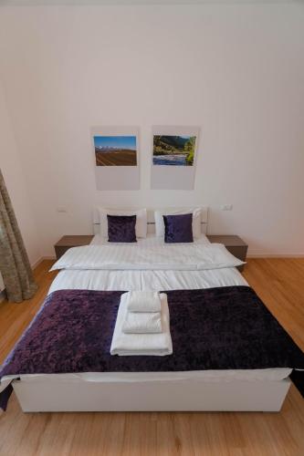 a bedroom with a large white bed with blue pillows at The Arc Residence in Astana