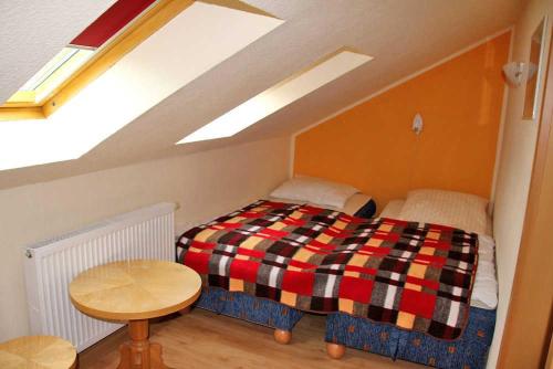 ベーレンシュタインにあるFerienhaus Baerenstein ERZ 1091の小さなベッドルーム(ベッド1台、テーブル付)