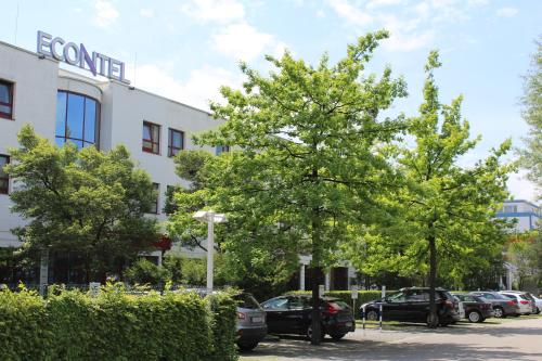 two trees in a parking lot in front of a building at AMBER ECONTEL in Munich