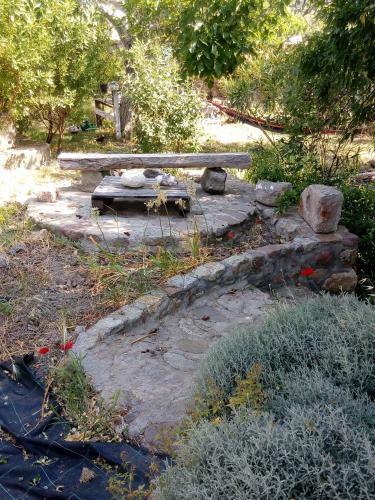 a garden with a bench and some plants and trees at Arcadia Guesthouse in Eresos