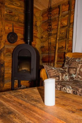 a fireplace in a log cabin with a cup on a table at Les Cabanes Du Saleve in Collonges-sous-Salève