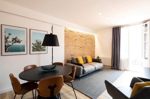 a living room with a table and a couch at Aspasios Sagrada Familia Apartments in Barcelona