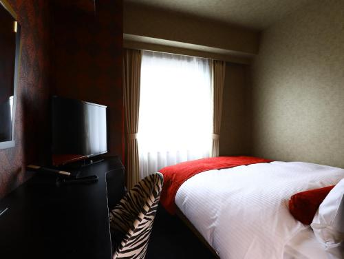 a bedroom with a bed and a flat screen tv at Hotel Wing International Select Osaka Umeda in Osaka