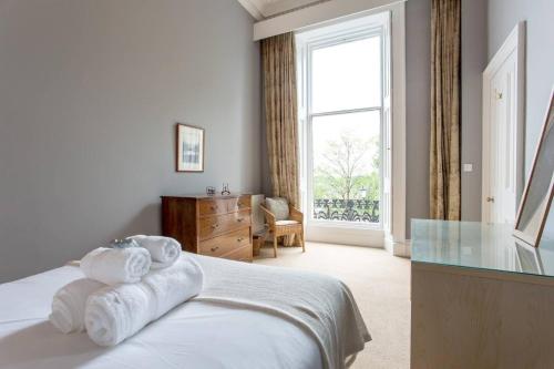 a bedroom with towels on a bed with a window at ALTIDO Spacious 2BR Apt in New Town, Prime Location in Edinburgh