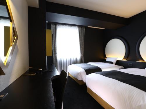 a hotel room with two beds and a window at Hotel Wing International Select Osaka Umeda in Osaka