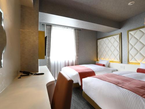 a hotel room with two beds and a window at Hotel Wing International Select Osaka Umeda in Osaka