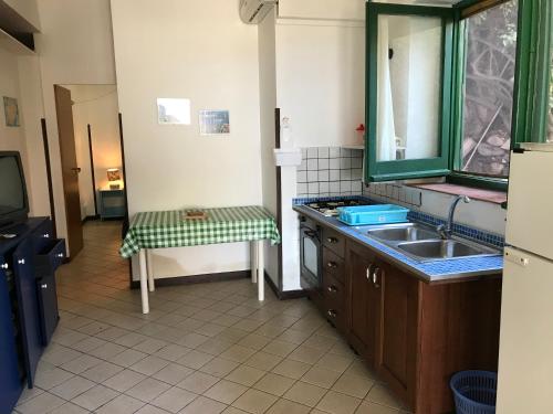 una piccola cucina con lavandino e specchio di Case del Tramonto a Ustica