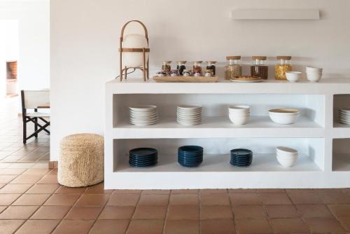 een witte plank met kommen en borden erop bij Hotel Es Blau Des Nord in Colonia de Sant Pere