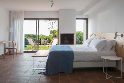 Hotel Es Blau Des Nord في كولونيا دي سانت بير: غرفة نوم بسرير كبير وطاولة وكراسي