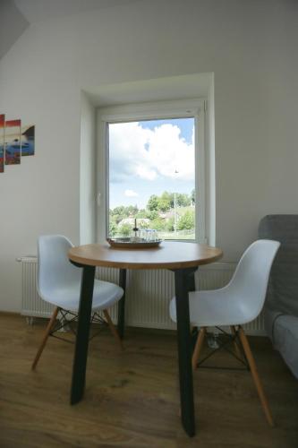 a table and two chairs in a room with a window at B&B Hotel Telsiai in Telšiai