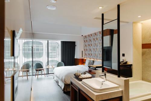 a hotel room with a bed and a sink and a bathroom at CHECK inn Taichung Zhongshan in Taichung