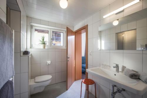 biała łazienka z umywalką i toaletą w obiekcie Frühstückspension Sport Mayr w mieście Söll