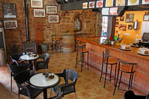 a restaurant with tables and chairs and a bar at Posada Ormas in Ormas