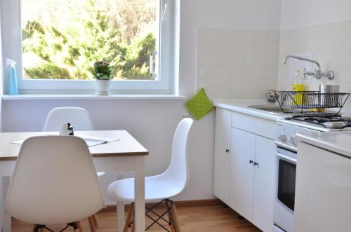 グダニスクにあるPrivate apartment near the city centreの白いキャビネット、テーブルと椅子付きのキッチンが備わります。