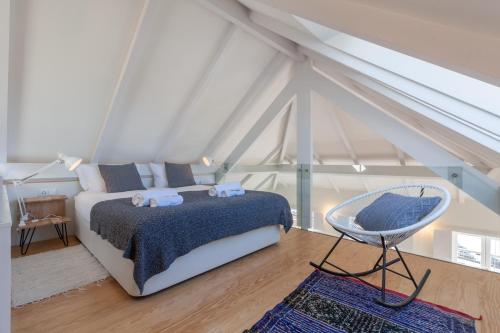 1 dormitorio con 1 cama y 1 silla en FLH Douro View Luxury Duplex, en Oporto