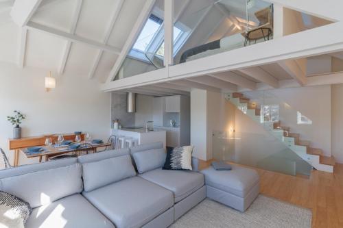 ein Wohnzimmer mit einem Sofa und einer Treppe in der Unterkunft FLH Douro View Luxury Duplex in Porto