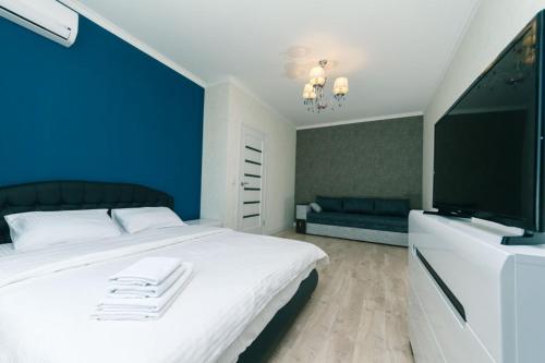 Schlafzimmer mit einem weißen Bett und einem Flachbild-TV in der Unterkunft Софии Русовой 7 in Kiew