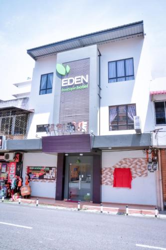 un edificio bianco con un cartello sul lato di Eden Boutique Hotel a Tawau